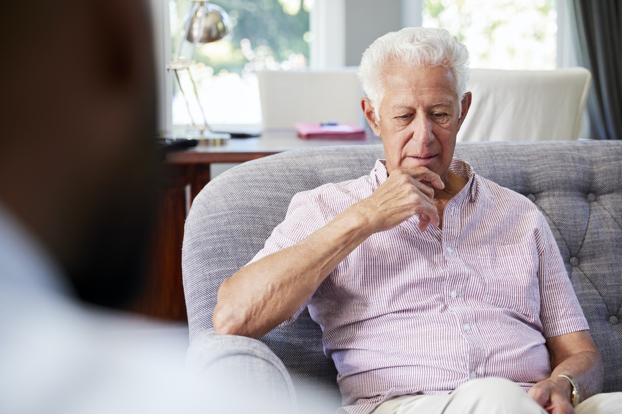 Senior man with depression having therapy with psychologist